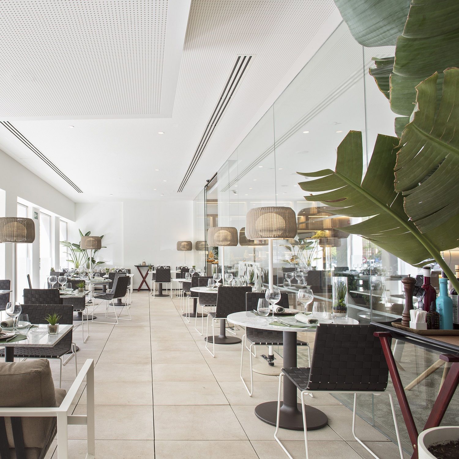 Innenansicht eines Restaurants mit Trenza SI0700 Outdoor Stühlen von Andreu World und gedeckten Tischen.