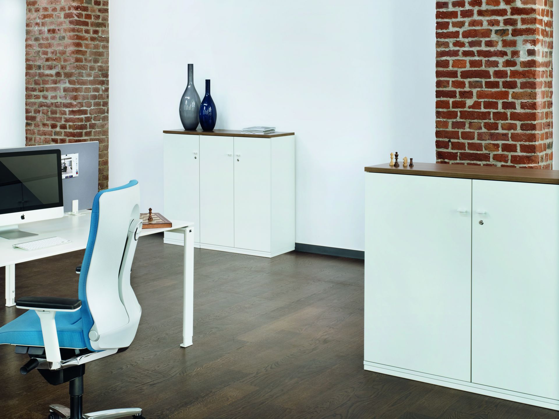 Büro mit weißen Aktenschränken, darunter Acta Regal von König+Neurath, und Büromöbeln.