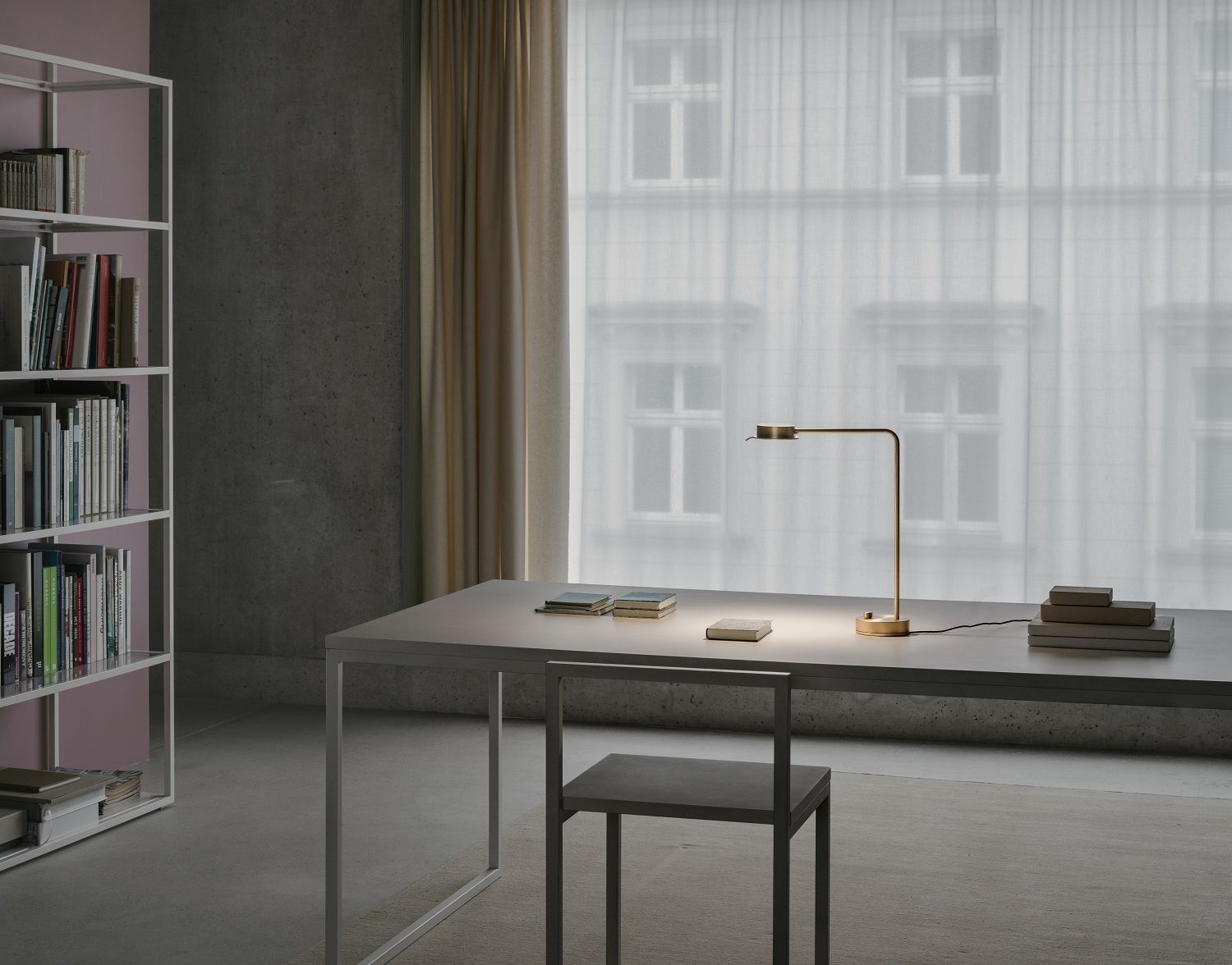 w102 B Chipperfield Tischleuchte von wästberg auf Schreibtisch mit Büchern vor Fenster.