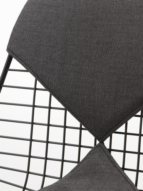 Detailaufnahme des Vitra Wire Chair Bikini Outdoor mit grauen Sitzkissen und schwarzem Drahtgestell.