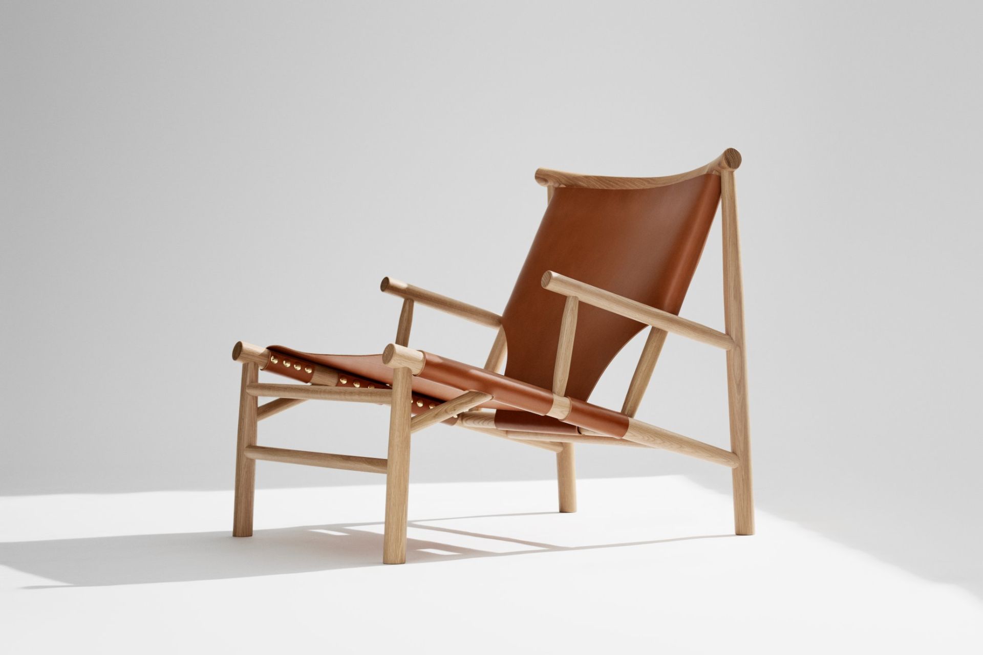 NORR11 Samurai Lounge Chair Sessel mit hellem Holzrahmen und braunem Lederbezug, seitliche Ansicht.