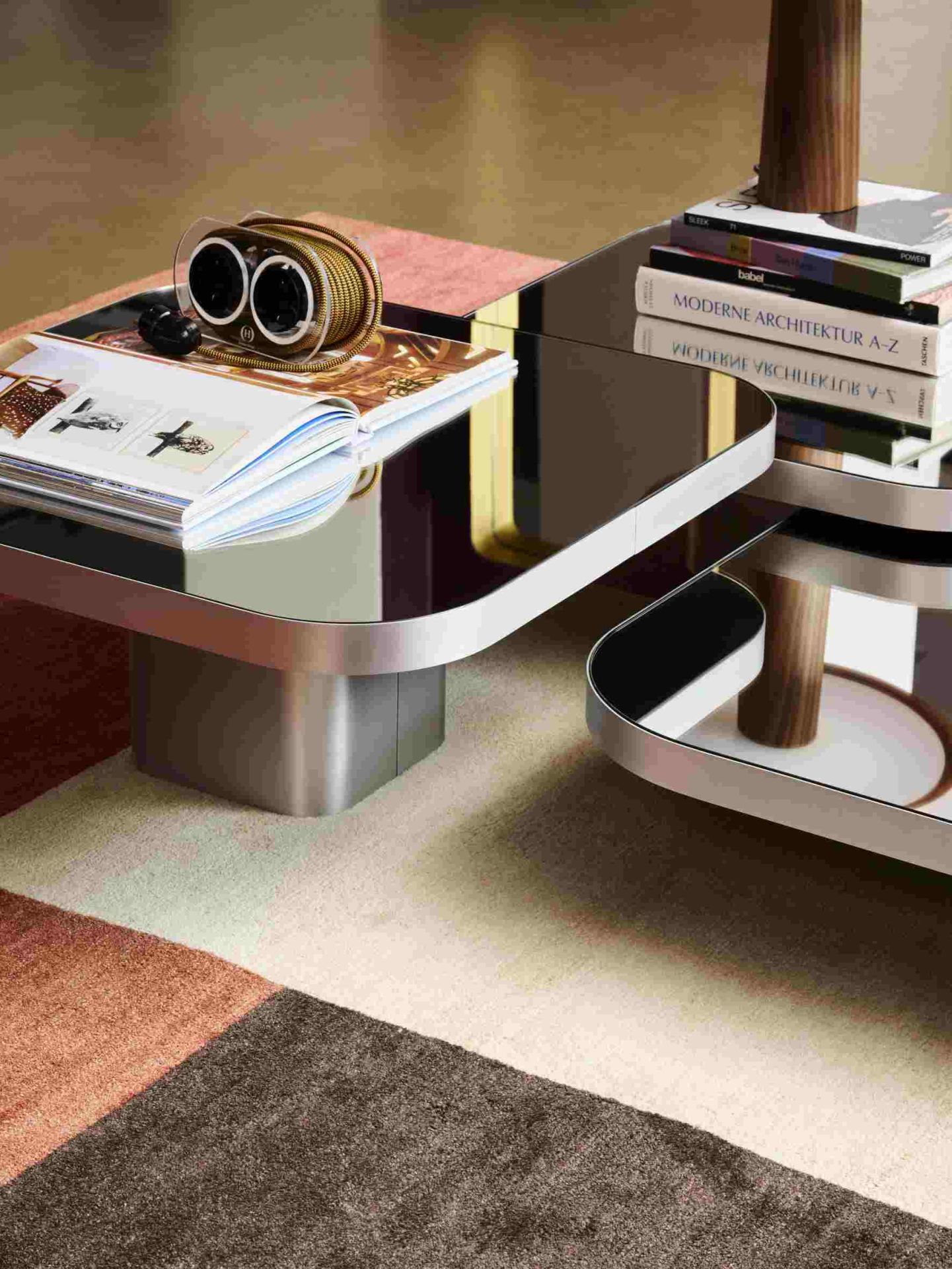 ClassiCon Bow Coffee Table No. 4 mit Spiegelglasplatte und Zeitschriften, Bücher und Deko auf modernem Teppich.
