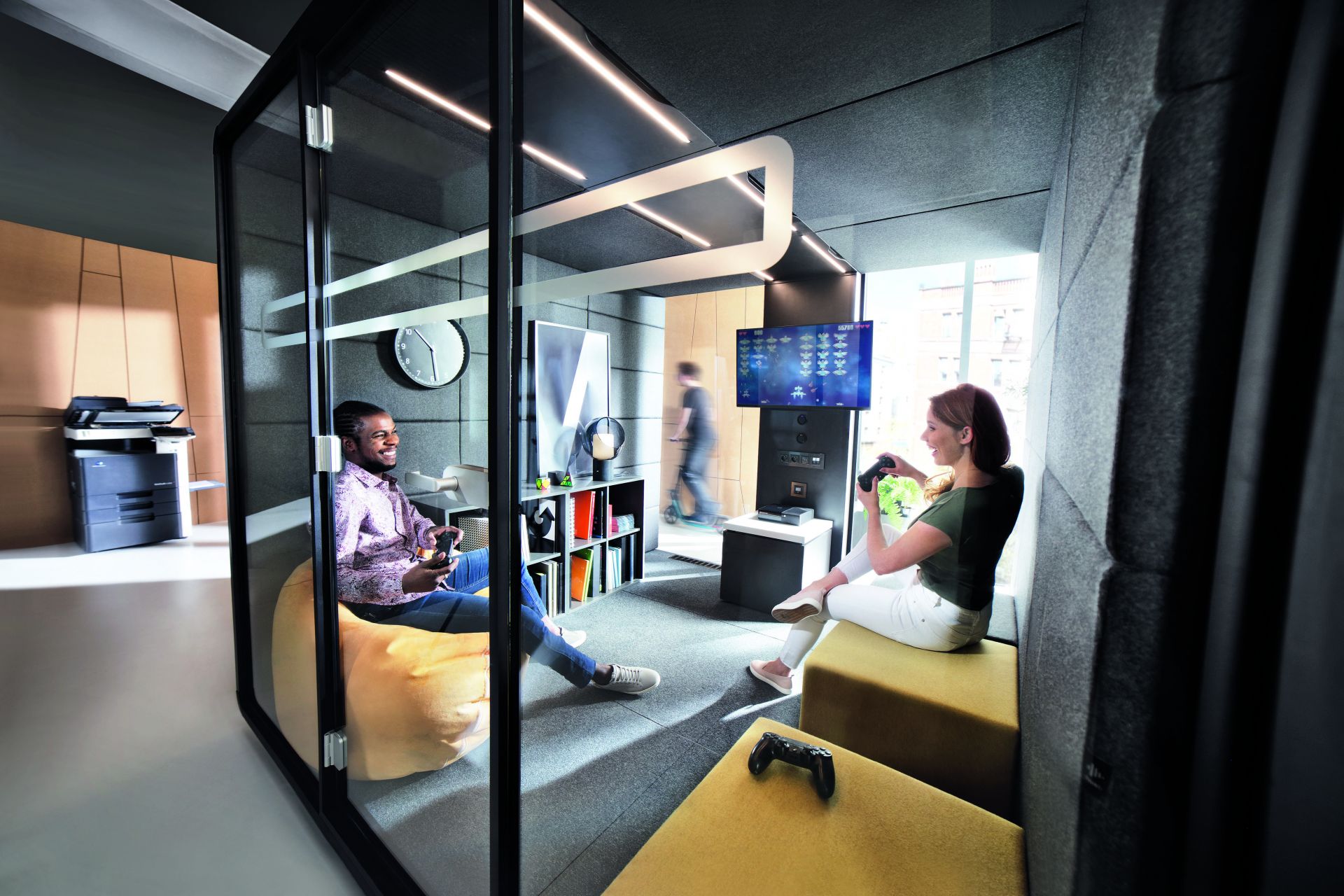 HushMeet L Meetingbox: Zwei Personen spielen Videospiele in einer modernen, schallisolierten Bürokabine.