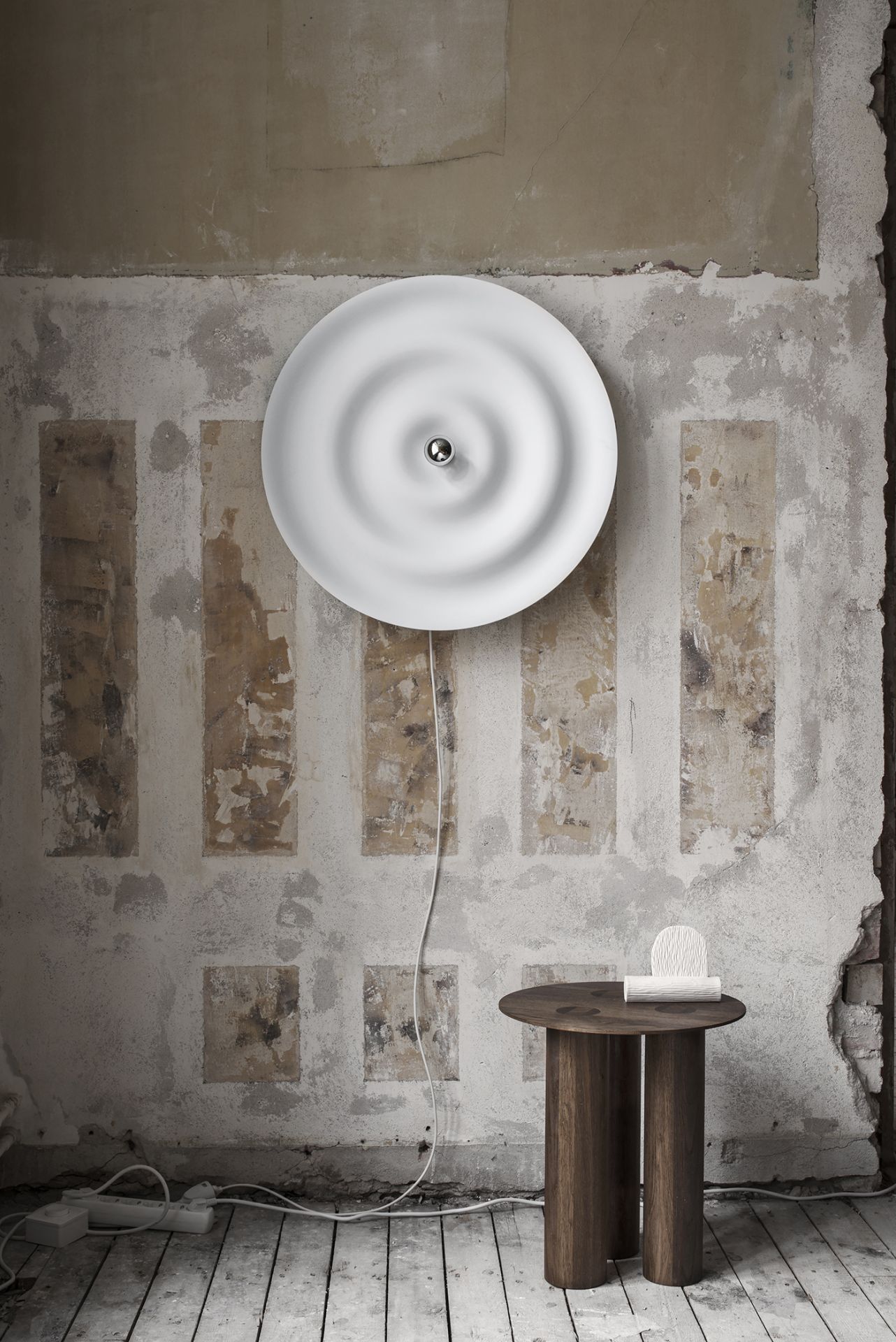 Weiße w171 Alma Wandleuchte von wästberg an einer Wand mit unebener Oberfläche. Design Lampe für Innenräume.