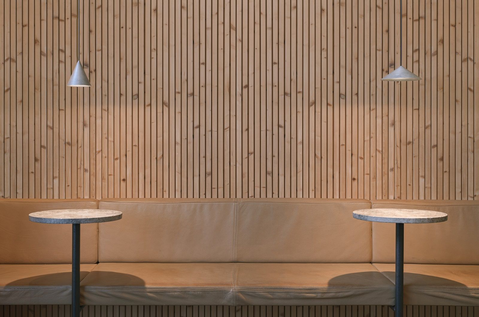 w201 S2 Extra small Pendelleuchte von wästberg über Tisch und Bank vor Holzpaneelwand.