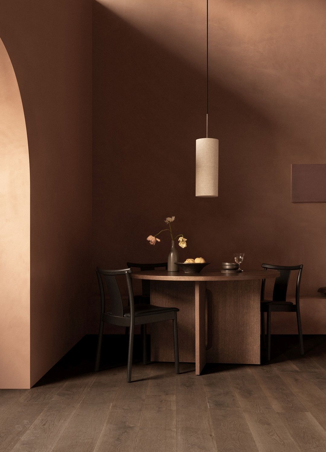 Merkur Dining Chair Stuhl von Audo Copenhagen an rundem Esstisch mit Lampe in braunem Raum.