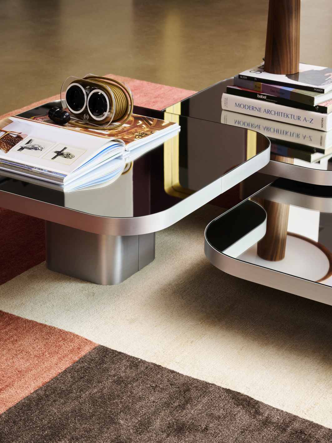 ClassiCon Bow Coffee Table No. 3 mit Glasplatte und verchromtem Gestell, dekoriert mit Buch und Deko.