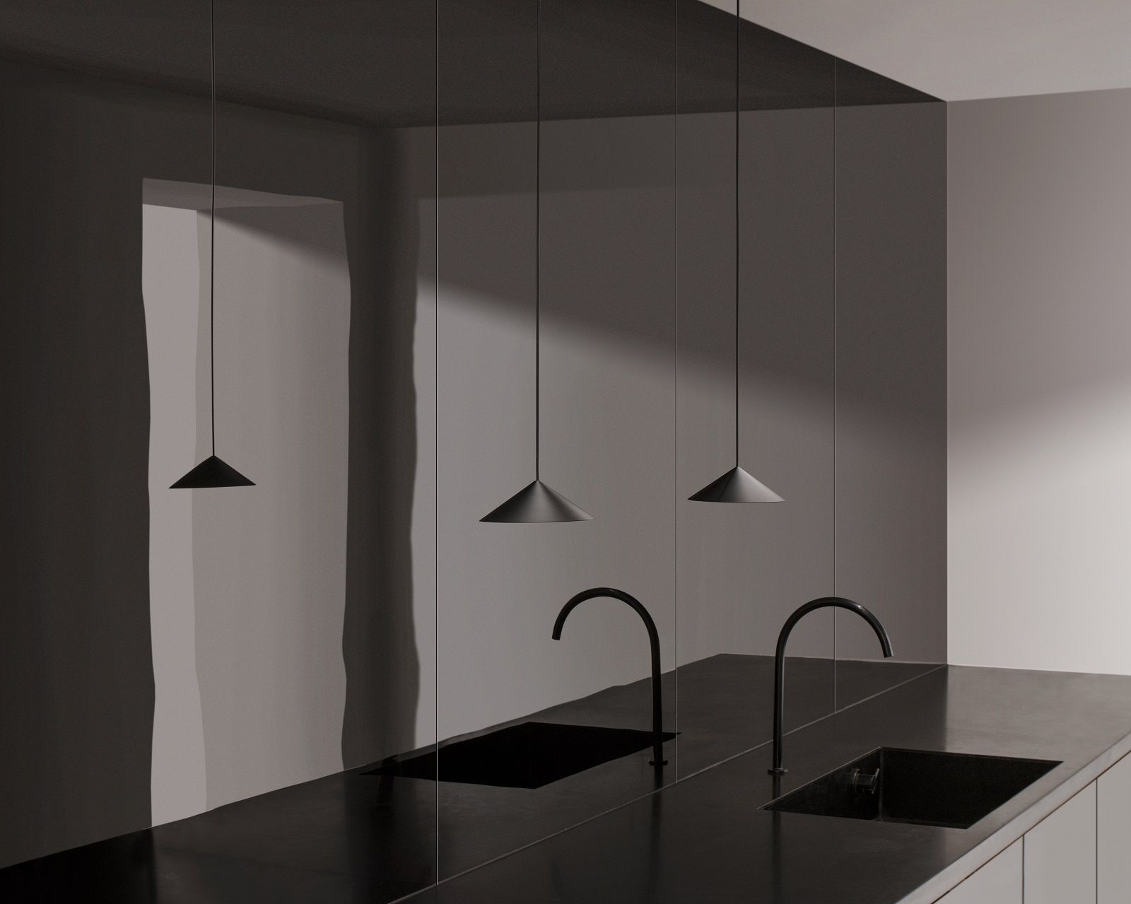 Drei minimalistische, schwarze w201 S3 Pendelleuchten von wästberg über einer modernen Kücheninsel mit Spülbecken.