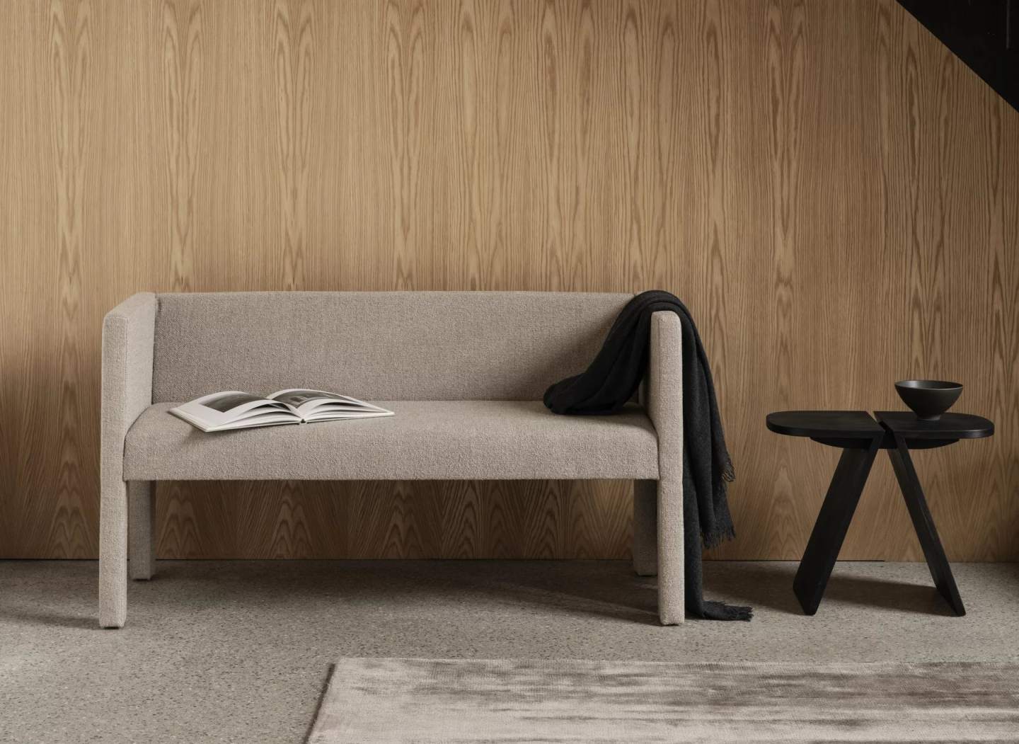 Beige Visca Rug Teppich von Blomus, stilvoller Wollteppich im Wohnzimmer unter einer modernen Sitzbank.