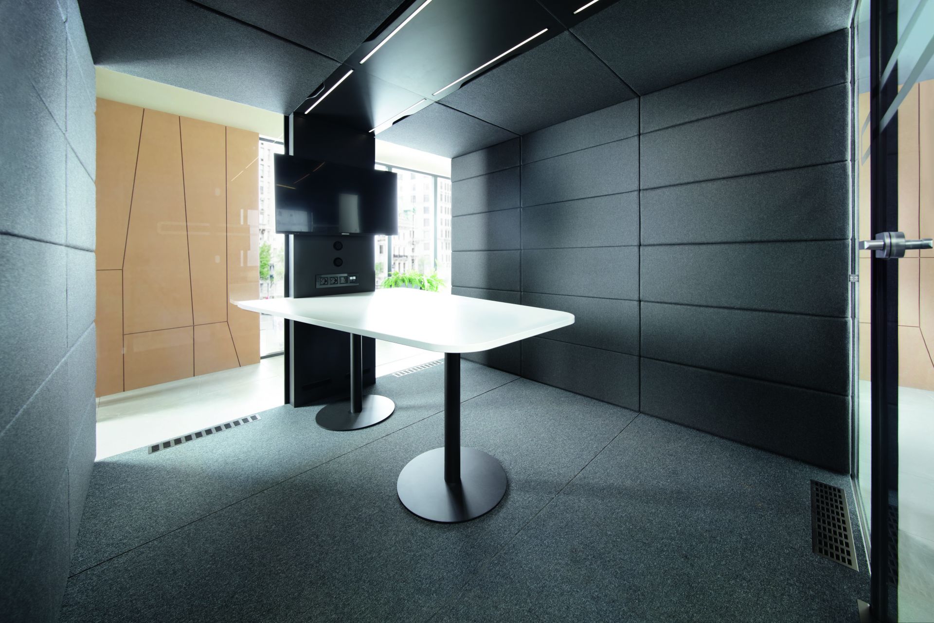 Modernes Bürointerieur mit weißem Besprechungstisch, grauem Teppichboden und Akustikpaneelen für Konferenzraum oder Meeting-Raum.