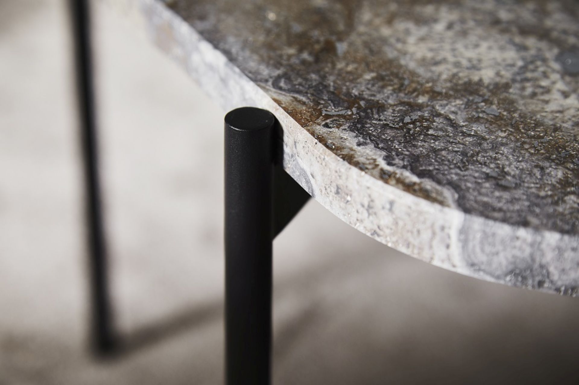 Detailaufnahme des La Terra Couchtischs von Woud mit melierter, grauer Tischplatte und schwarzen Metallbeinen.