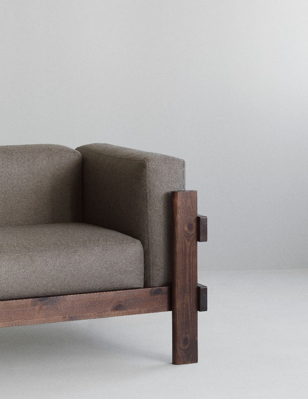 Detailaufnahme vom Kube Sofa von Normann Copenhagen mit braunem Stoffbezug und Holzrahmen.