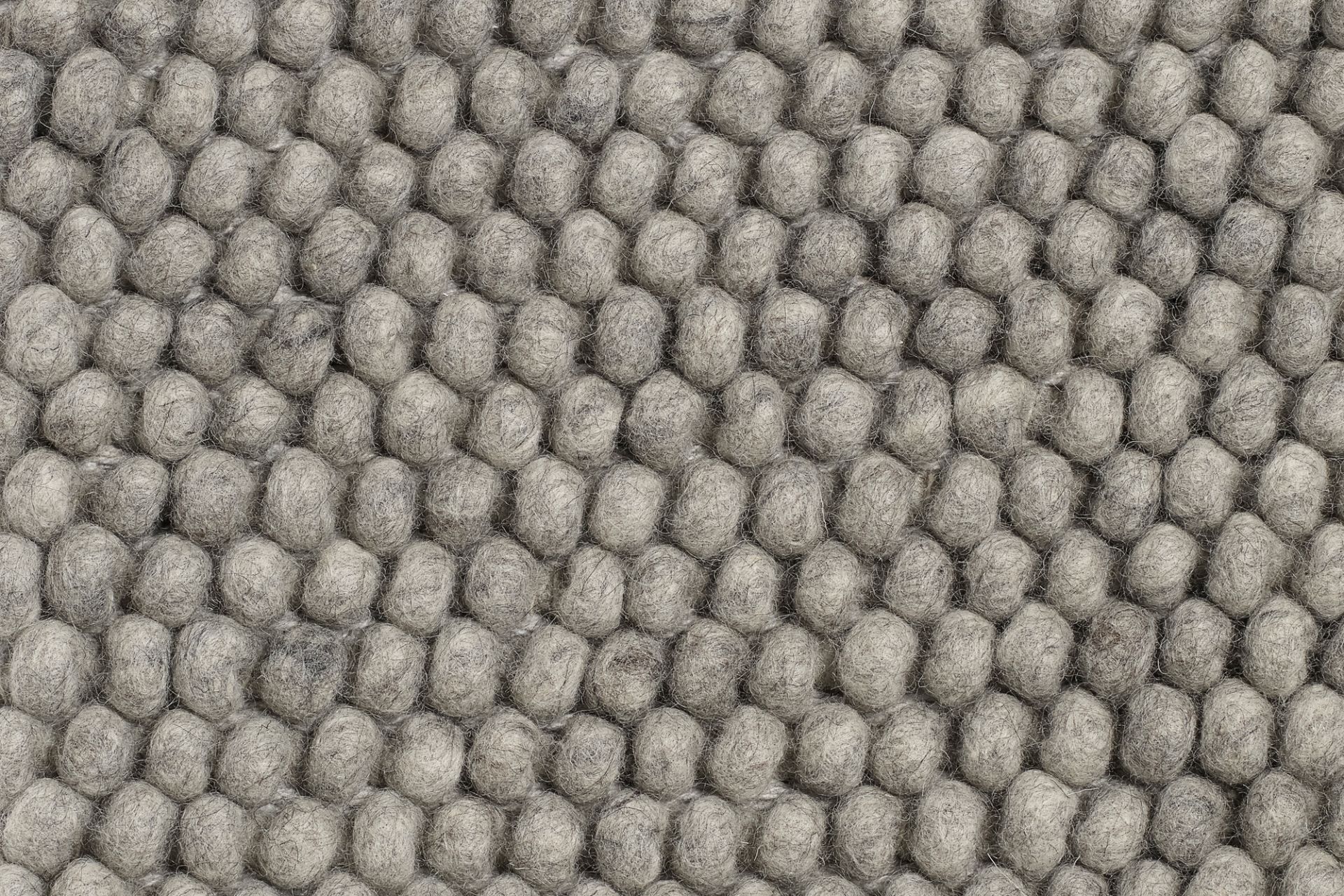 Detailaufnahme des mittelgrauen Peas Teppichs von Hay, bestehend aus vielen Wollkugeln.