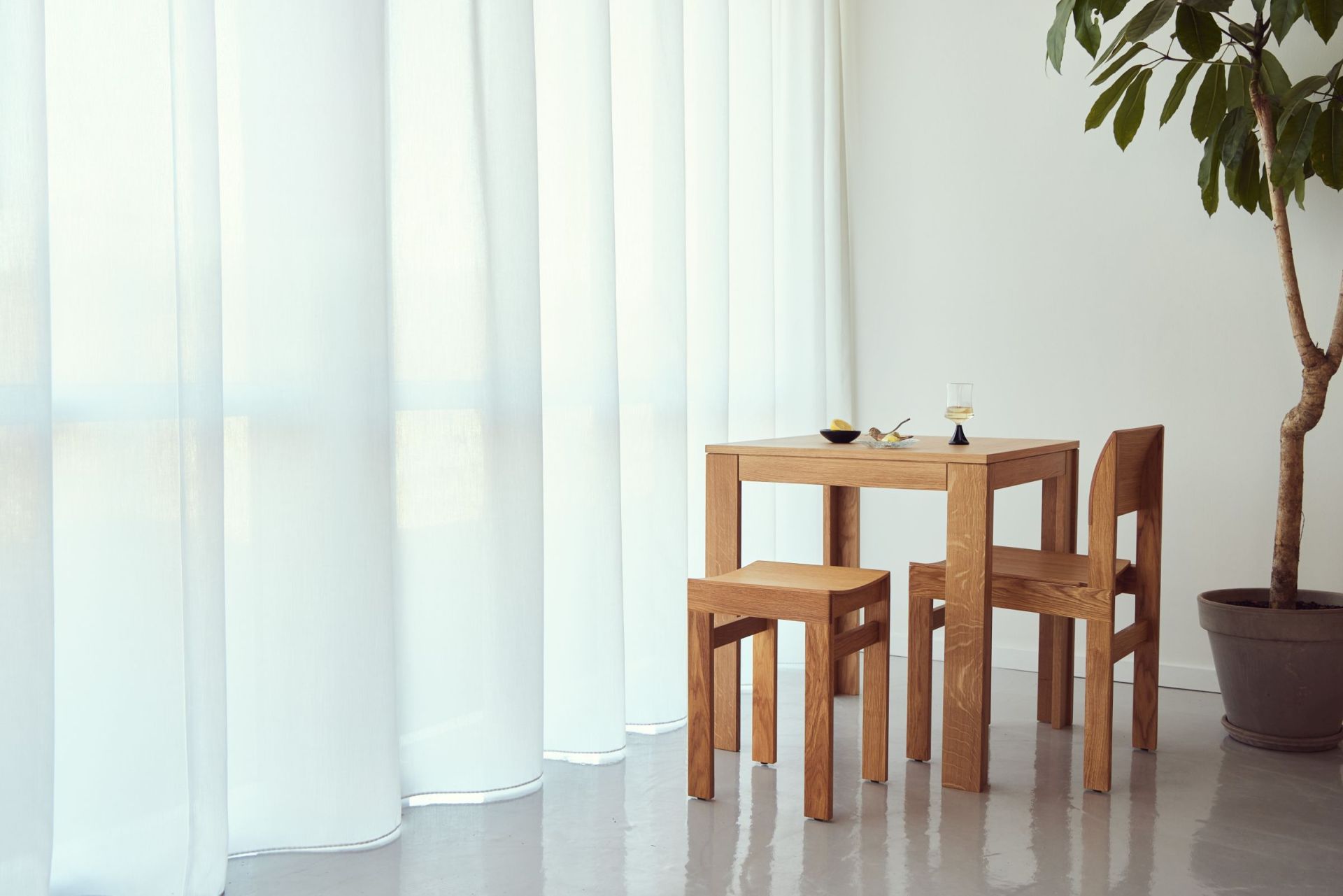 Sonder Hocker von Form & Refine aus Eiche mit passendem Esstisch und Stuhl.