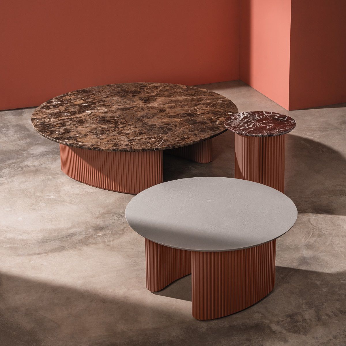 Andreu World Bolete Couchtische: Moderner Wohnzimmertisch mit Marmorplatte und gerippter Basis in Terrakotta.