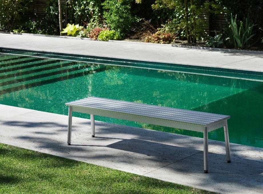 Ex Bank Outdoor von Normann Copenhagen, moderne Gartenbank aus Aluminium neben einem Pool.