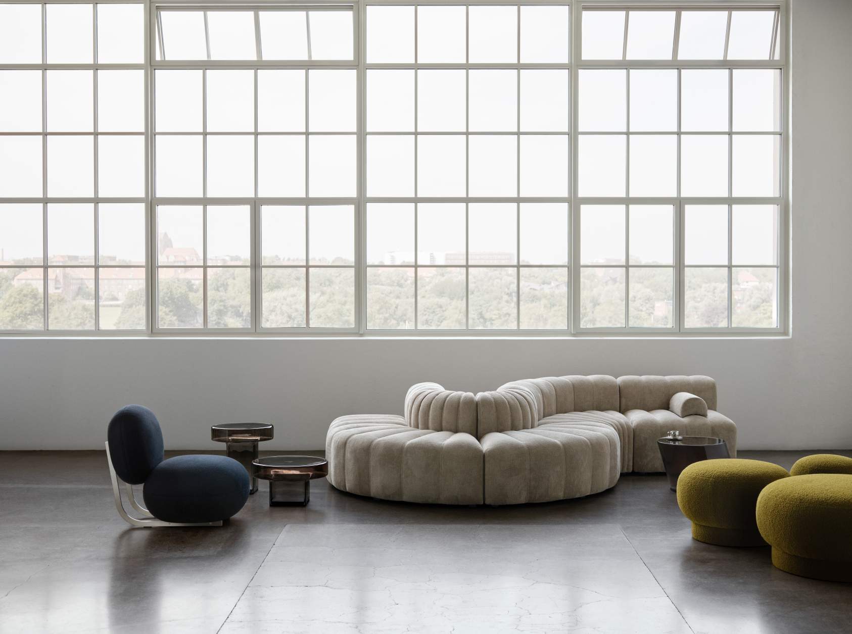 NORR11 Copper Lounge Chair Sessel mit Edelstahlgestell in modernem Wohnraum mit Sofa und Hockern.
