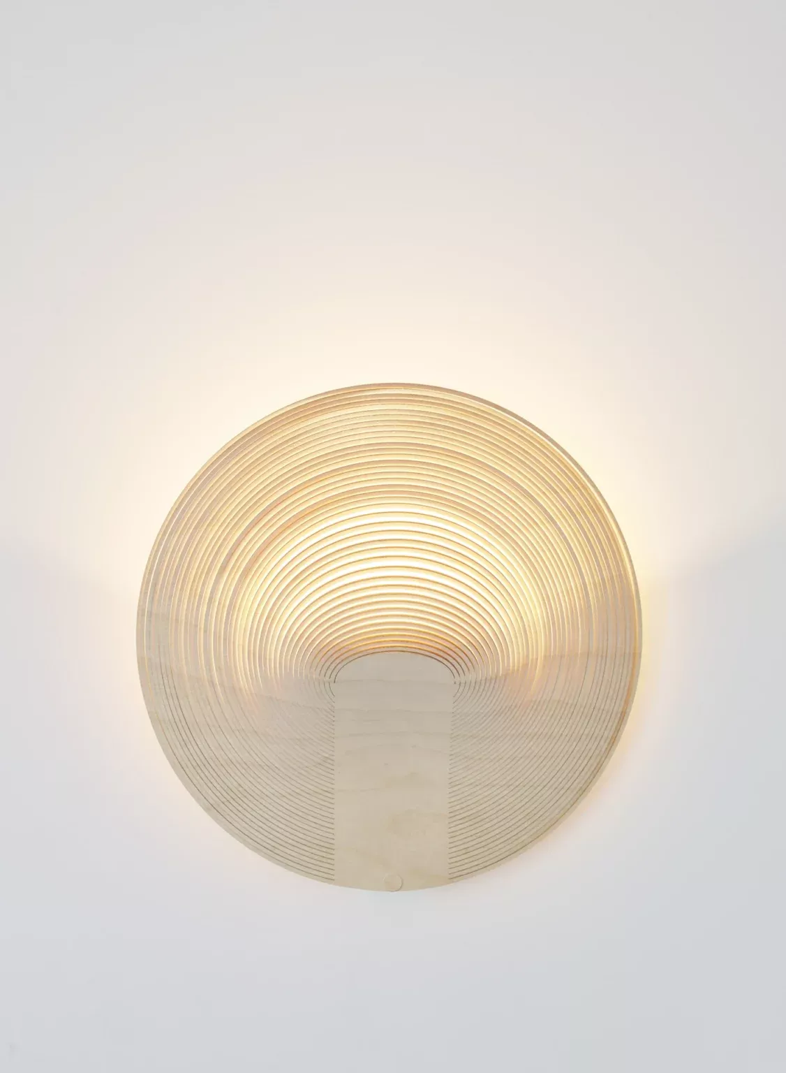Illan Wandleuchte von Luceplan: Runde, moderne Designleuchte aus Holzfurnier an einer weißen Wand.