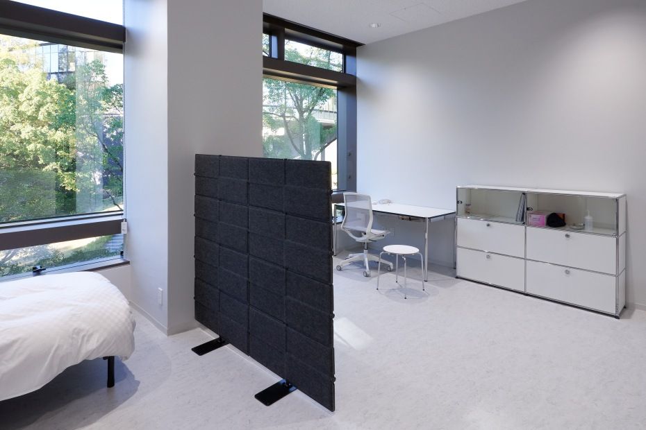Grauer USM Haller Privacy Panel Raumteiler in modernem Büro mit Schreibtisch und USM Möbeln.