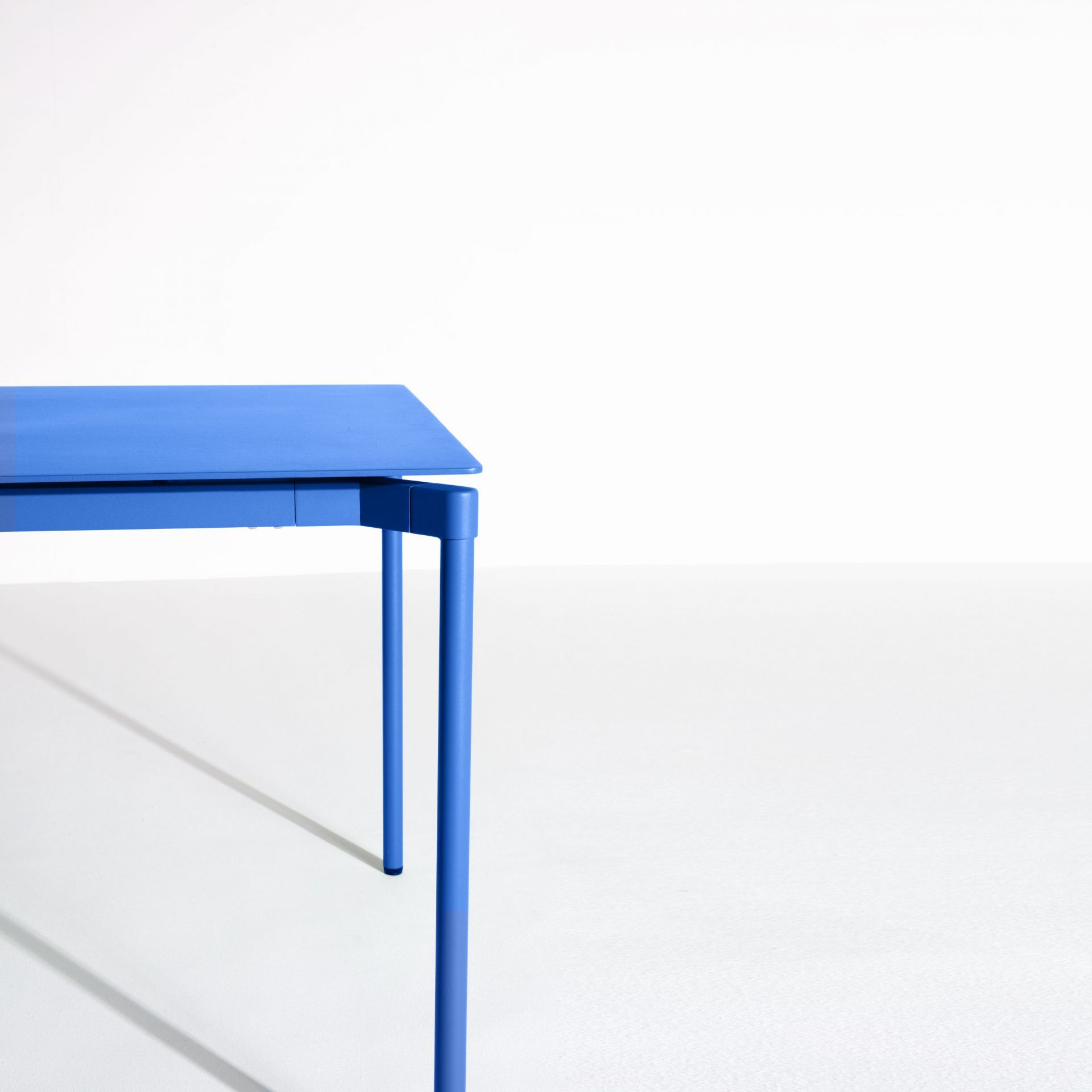Blauer Fromme Esstisch von Petite Friture, rechteckig, mit minimalistischem Design und filigranen Tischbeinen.