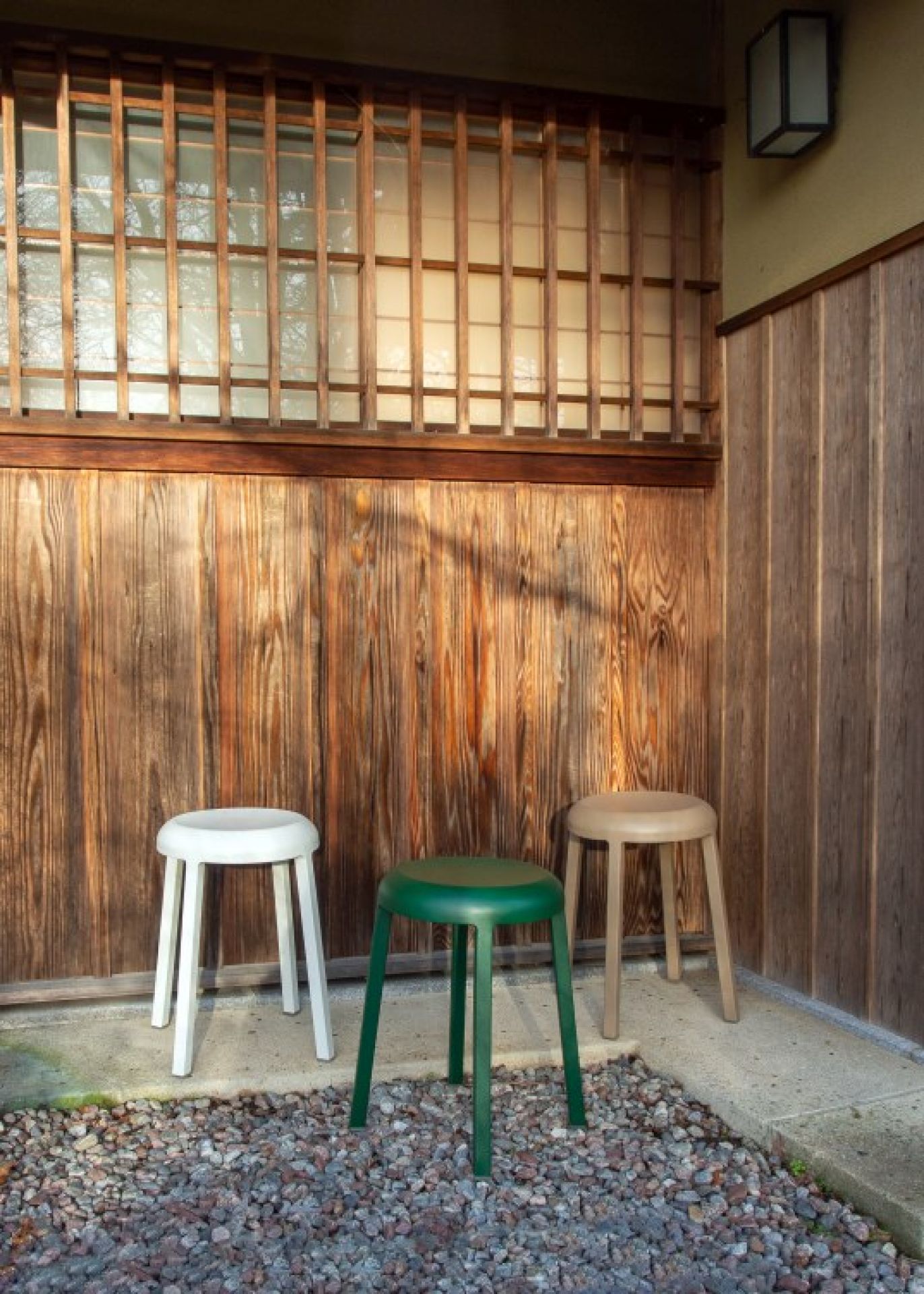 Drei Za Stool Hocker von Emeco in Weiß, Grün und Beige vor einer Holzwand.