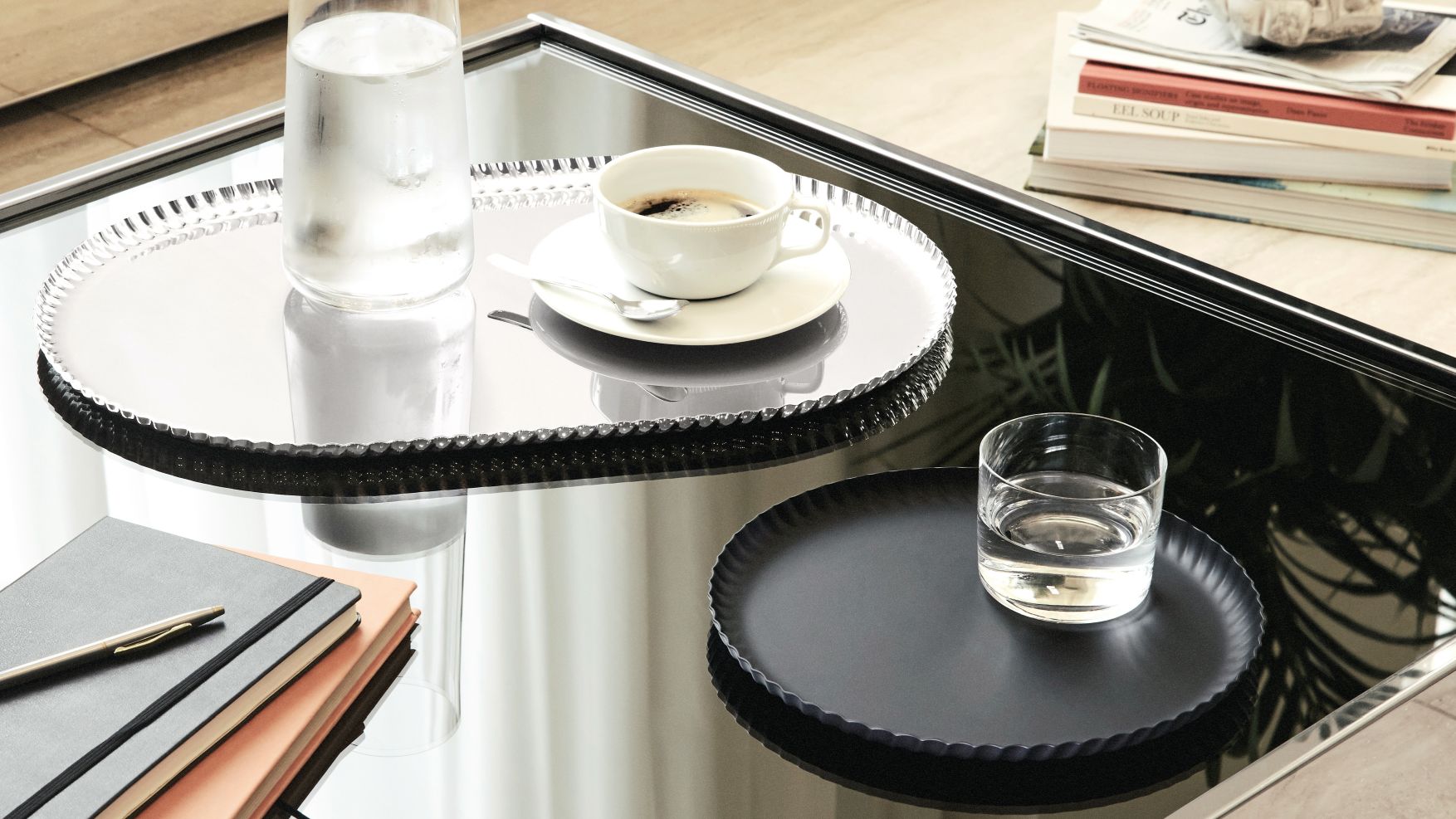 JK01/46B Alessi Tablett: Silbernes und schwarzes Serviertablett mit Getränken und Kaffeetasse auf einem Tisch.