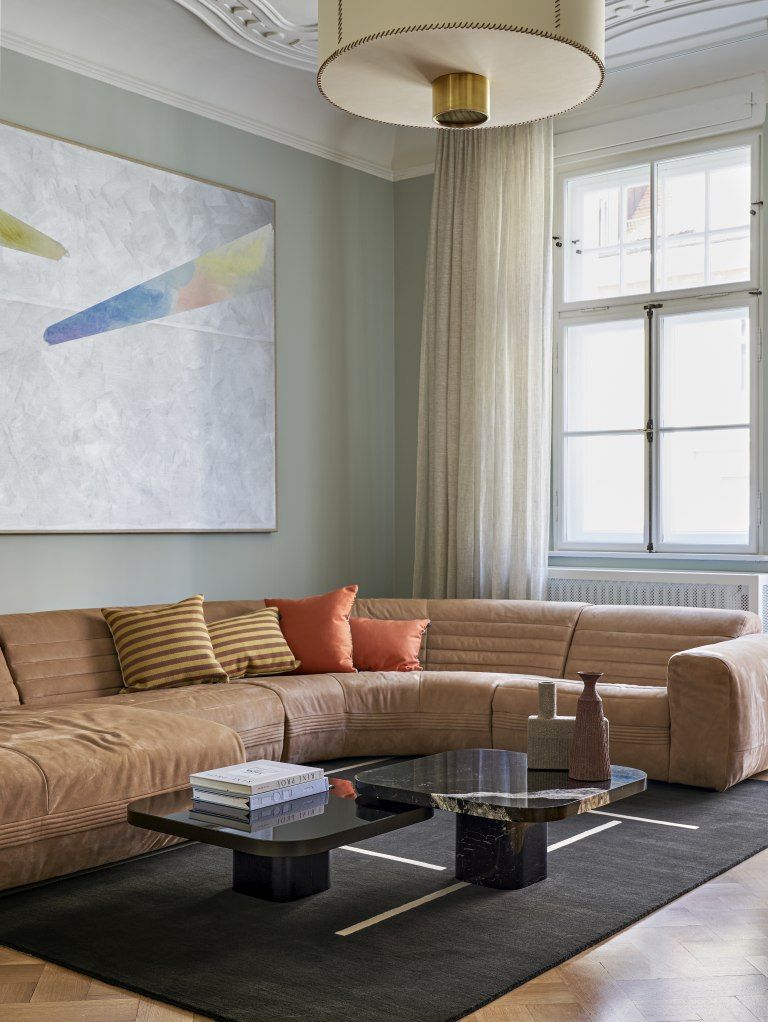 ClassiCon Bow Coffee Table No. 2 im modernen Wohnzimmer mit braunem Sofa und Teppich.