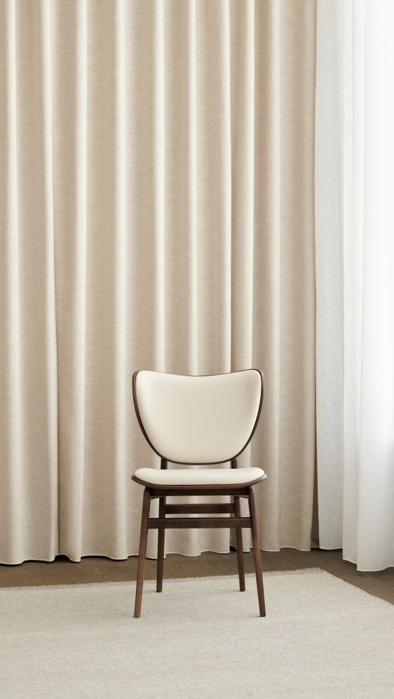 Frontansicht des NORR11 Elephant Dining Chair Stuhls mit cremefarbener Polsterung und dunklem Holzgestell.