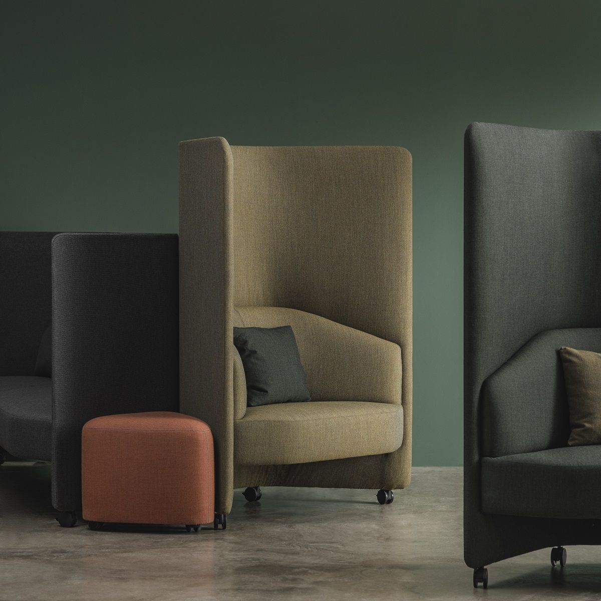 In Out Office Hocker RS2264 von Andreu World, orangefarbener Ottoman auf Rollen vor Loungesesseln.