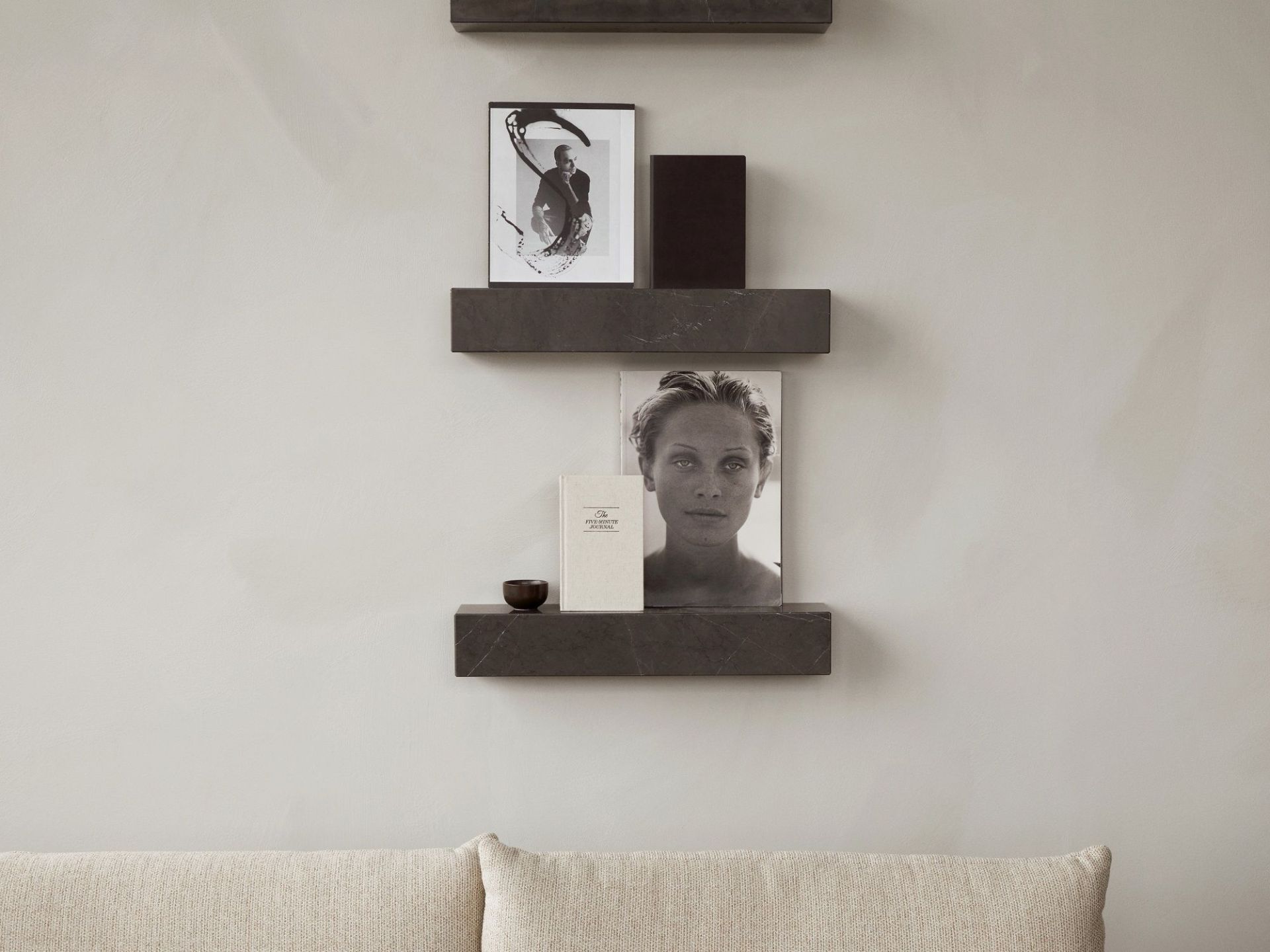Nahaufnahme von drei grauen Audo Copenhagen Plinth Shelf Regalen an einer Wand mit Deko.