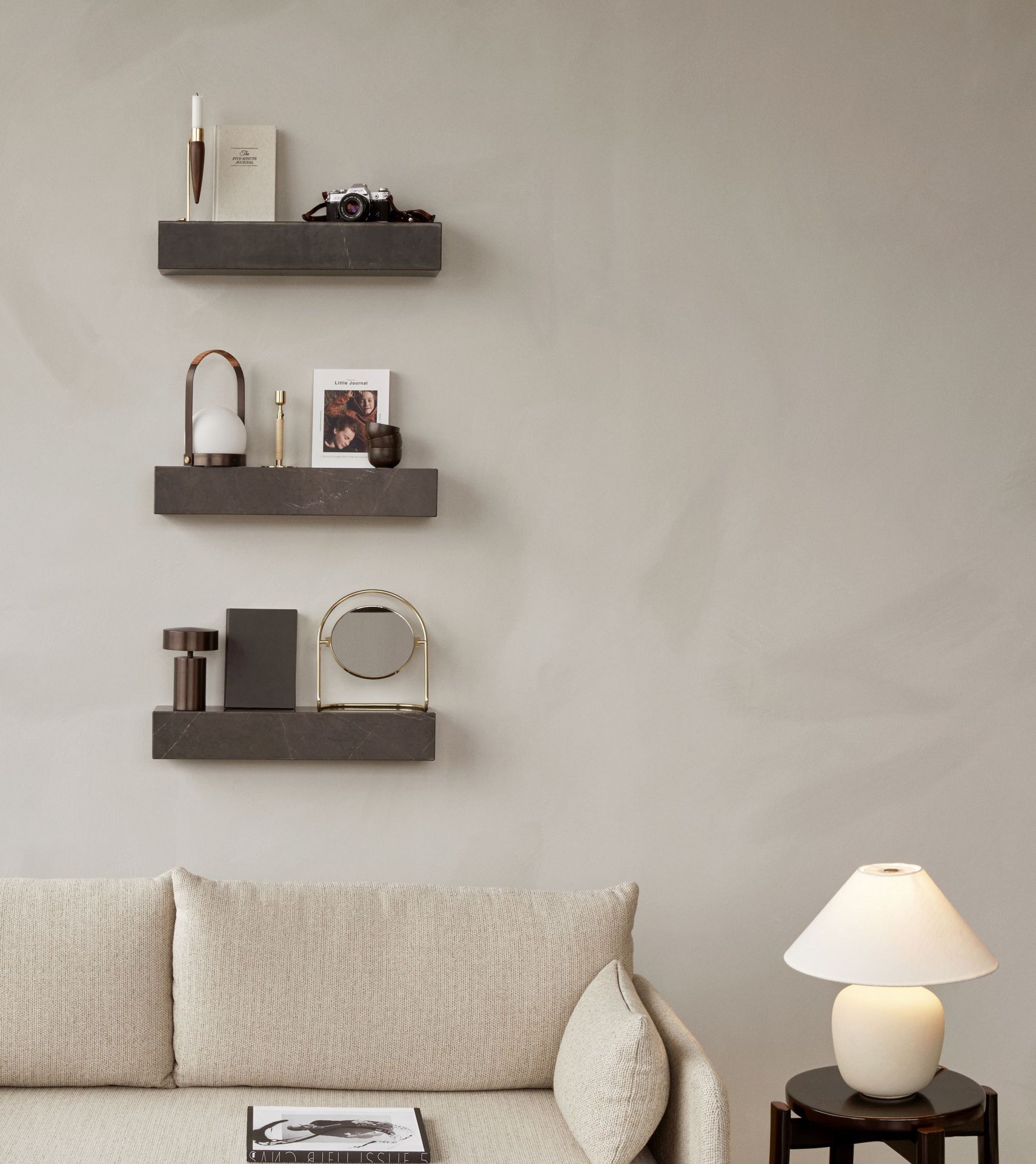 Nahaufnahme von drei grauen Audo Copenhagen Plinth Regalen an einer Wand, dekoriert mit Wohnaccessoires.