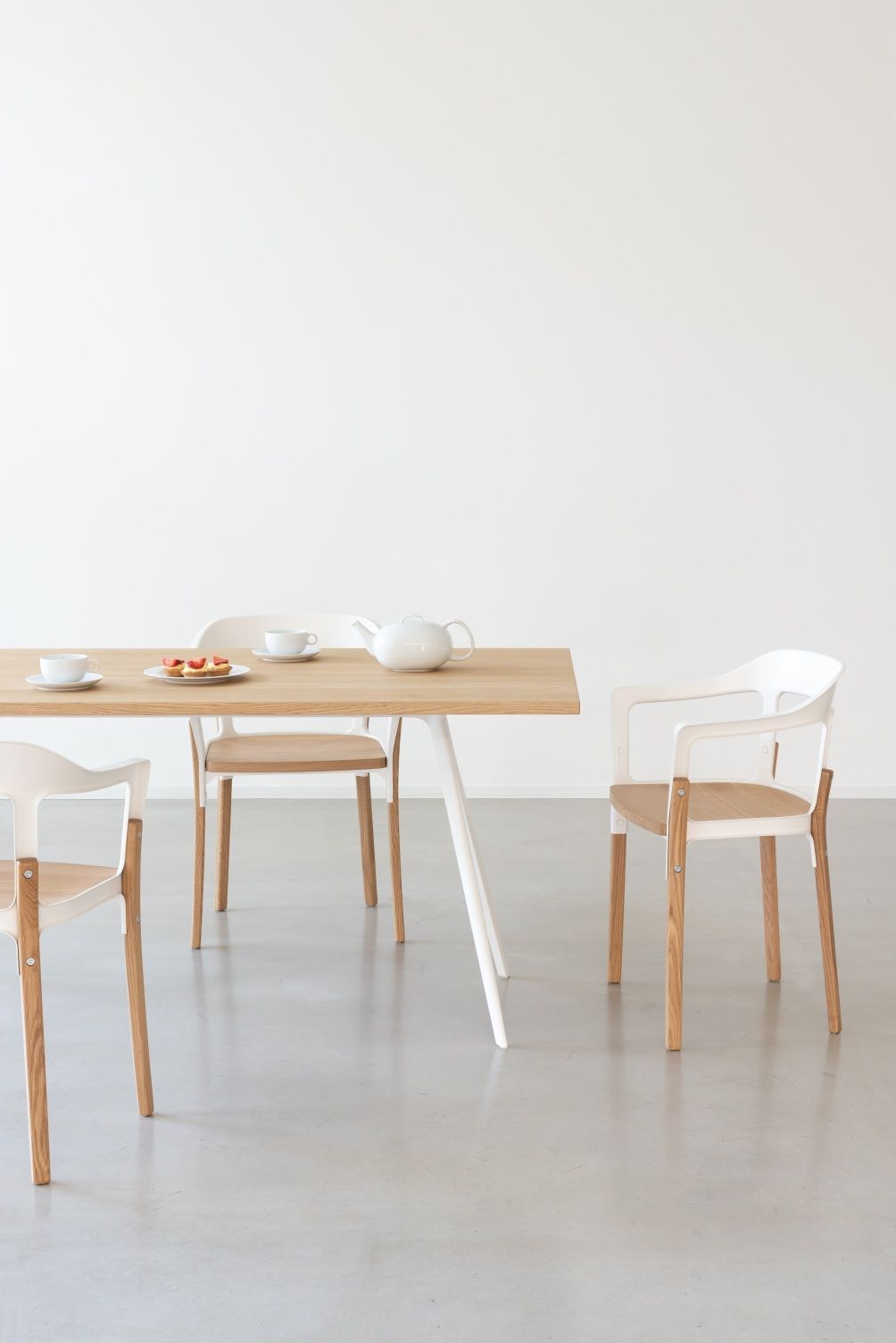 Magis Steelwood Chair Stühle in Weiß und Holz an Esstisch mit Teegeschirr.