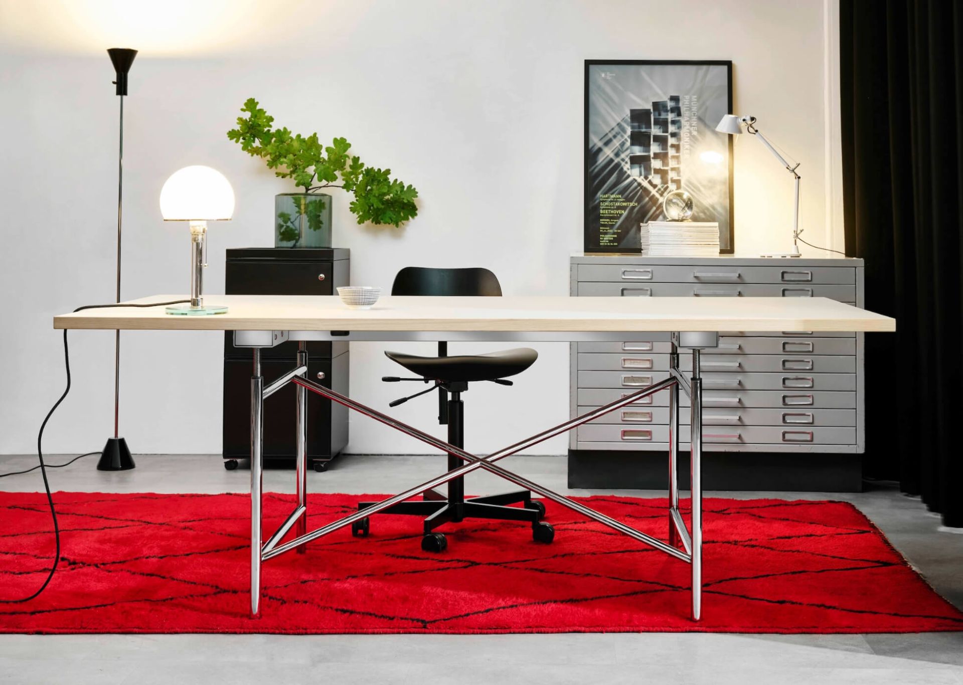 Eiermann Tisch mit elektrischer Höhenverstellung von Richard Lampert, helle Tischplatte, verchromtes Gestell, roter Teppich im modernen Büro.