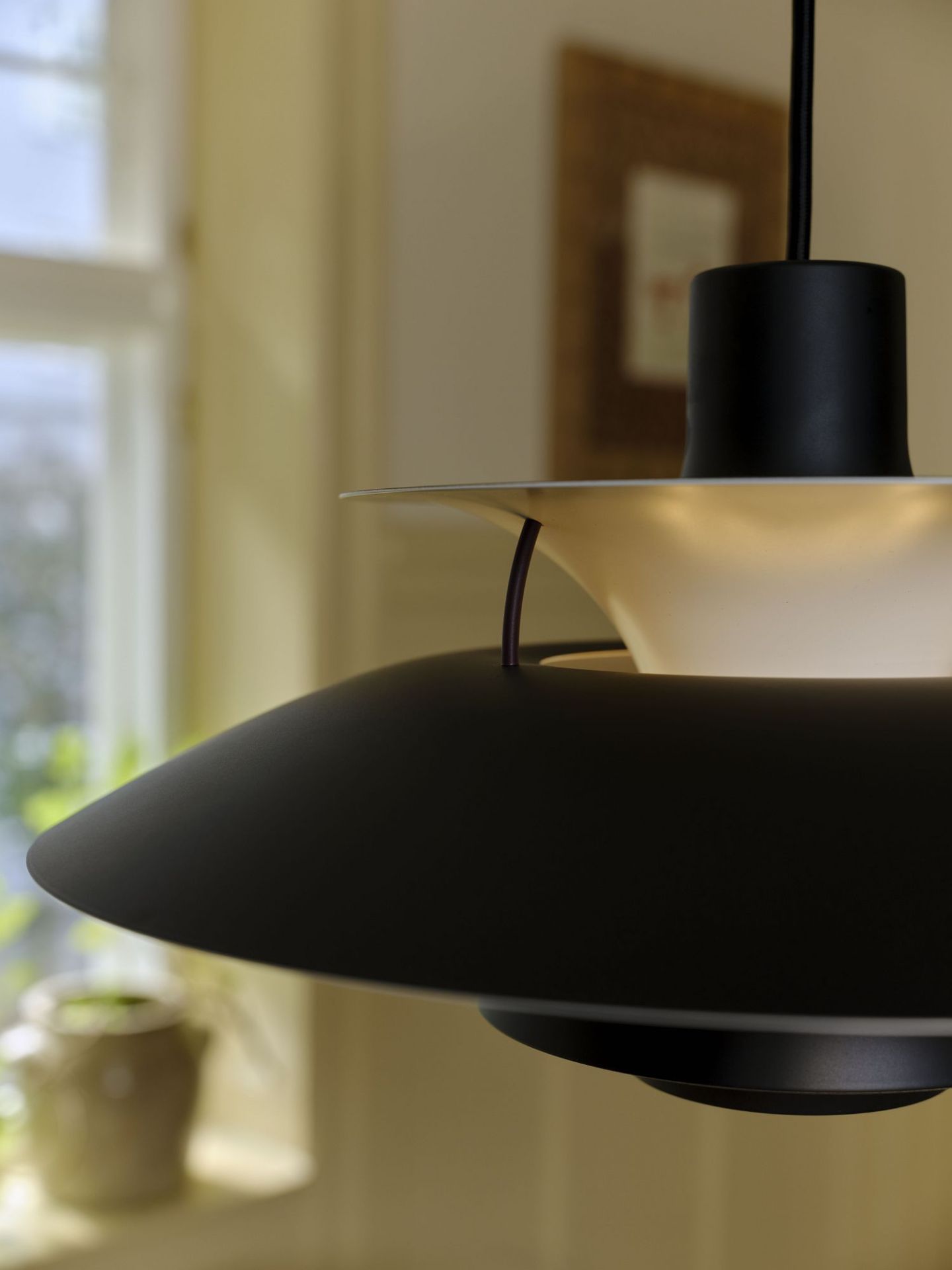 Detailaufnahme der schwarzen PH 5 Mini Pendelleuchte von Louis Poulsen, ein Designklassiker für stilvolle Beleuchtung.