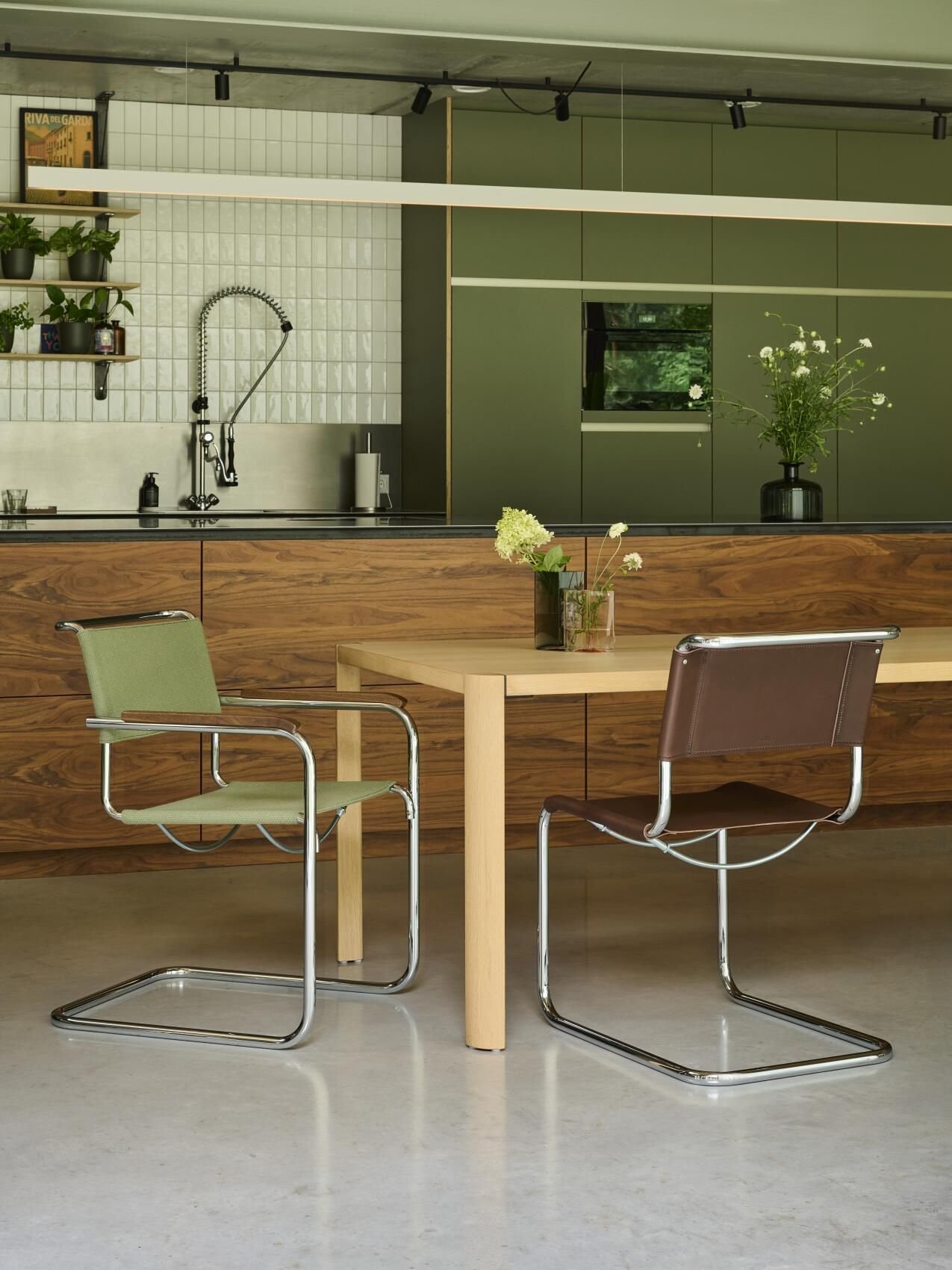 Zwei Thonet S 34 Freischwinger Stühle in Leder und Stoff am Esstisch in moderner Küche.